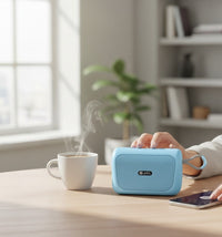 Swiss Military Audio ANCHA MI portable light blue Bluetooth speaker with fabric grille and carrying loop, held in a hand.